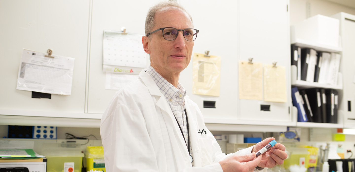 Dr. Jerry Teitel examines a blood sample from one of his patients. Dr. Teitel is a collaborator with a U.S.-based gene therapy trial for hemophiliacs. (Photo by Katie Cooper)